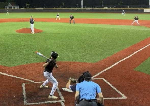 Young hitter in the cage tracking a pitch out of the machine