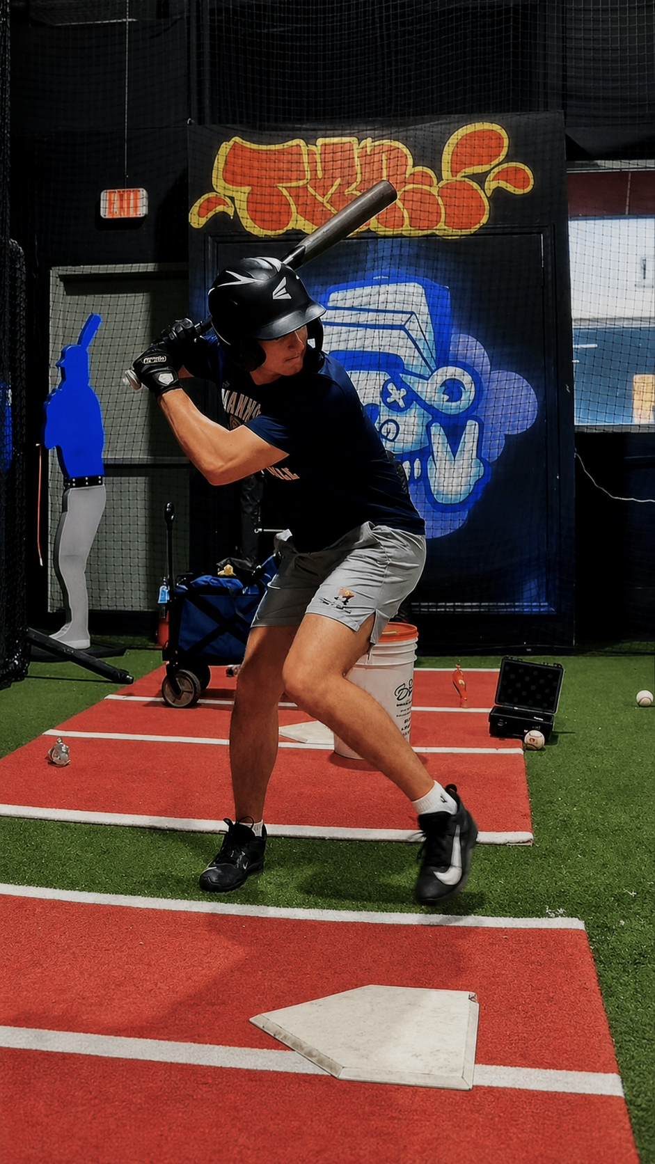 A young hitter holding the launch position during a private swing-mechanics lesson