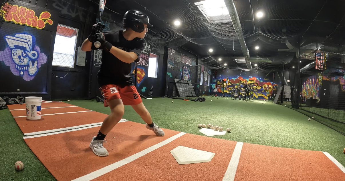 Youth hitter in a strong launch position during a cage session